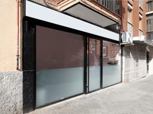 Facade of a commercial premises seen from the cobbled street with windows and black metal Facade of a commercial premises seen from the cobbled street with windows and black metal
